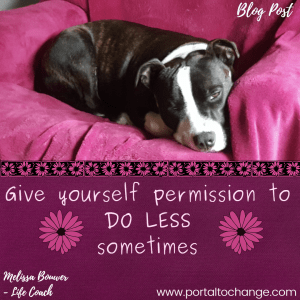 A brindle American Staffie with white facial. and leg markings snuggled up on a pink blanket. A black and pink daisy border separates the image with text below: "Give yourself permission to DO LESS sometimes". Two pink daisies on either side of the text in light pink with a pink daisy on either side of the text. Text is matted on a dark purple background. 